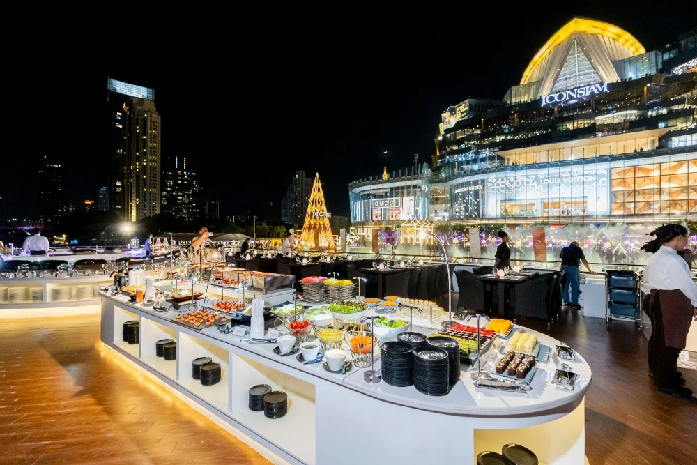 Tourists enjoying buffet dinner on Bangkok river cruise.